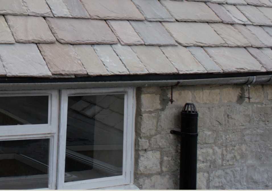 Cotswold roof stone laid in diminishing courses above a cottage window